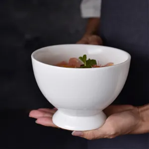 Minimalist white ceramic pedestal bowl with glossy finish for cereal or fruit salad