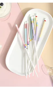 Detailed view of macaron-colored ceramic chopsticks with geometric patterns on a white tray