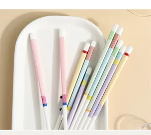 Macro shot of colorful ceramic chopsticks with geometric patterns on a white porcelain dish