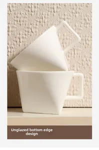 Detail of unglazed bottom edge on white geometric ceramic coffee mug for anti-slip grip