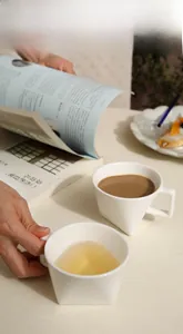 Detail view of stylish white ceramic coffee mugs in creative triangular and square designs