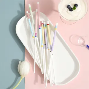 Elegant white ceramic chopsticks with colorful mosaic patterns on pastel background