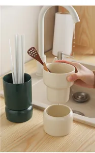 Detail of ceramic cutlery holder showing drainage holes and matte textured finish