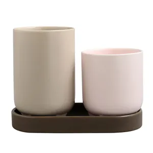 Minimalist ceramic chopstick holder set with grey and pink cups on a dark drip tray