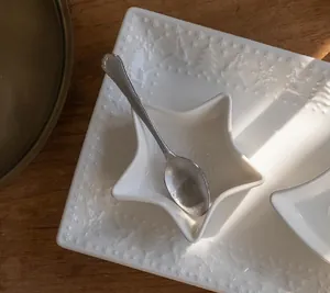 Detail of star-shaped ceramic bowl and embossed rectangular plate with holiday motifs