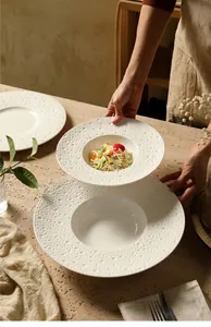 Detail van wit keramisch pastabord met elegante gehamerde textuur en loodvrije glazuur
