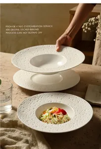 Detail van een crèmekleurig keramisch diep bord met salade en getextureerd oppervlak