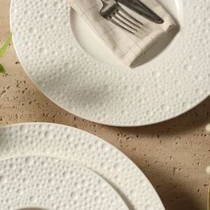 Minimalistisch beige keramisch pastabord met unieke textuur van bubbelreliëf