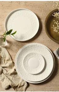 Macro view of cream ceramic plate set with embossed bubble texture and smooth glazed surface
