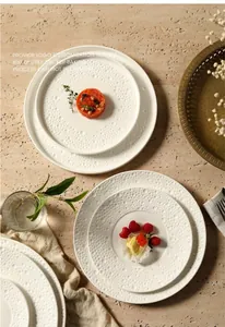 Detailed view of white embossed ceramic plates with dot texture for Nordic dining