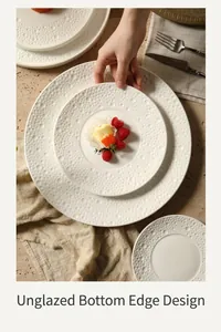 Detail of white ceramic dinner plates with bubble texture and unglazed non-slip bottom