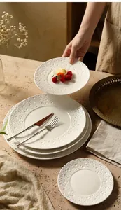 Detailed view of white ceramic plate featuring elegant pearl embossed bubble rim texture