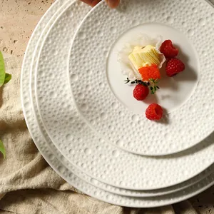 Minimalist white ceramic round plates with embossed bubble texture for upscale dining
