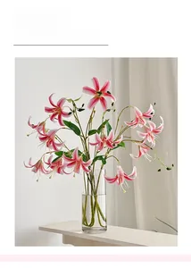 Detail of life-like pink lily petals and clear glass vase in a bright indoor setting