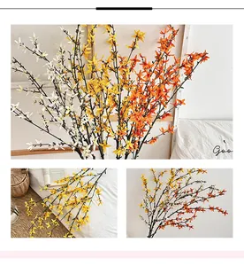 Macro detail of artificial forsythia branches with lifelike yellow and orange blossoms