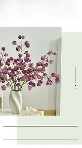 Detail of purple artificial lantern fruit stems in a white spiral ceramic vase decor
