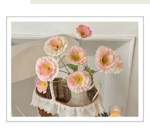 Vue détaillée de pavots en soie rose avec tiges texturées dans un panier en dentelle
