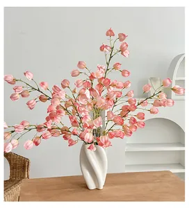Pink bell-shaped artificial flowers in a modern twisted white ceramic spiral vase decoration