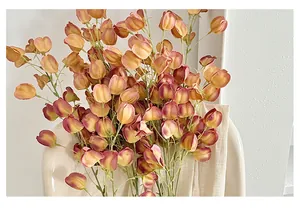 Close-up of realistic orange Physalis faux stems in a white vase for home decor