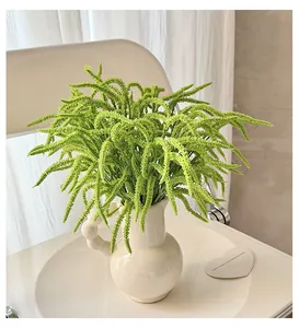 Close-up of hanging green artificial plant in white ceramic vase for home decor