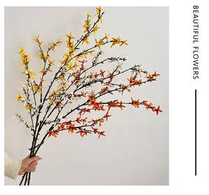 Close-up of artificial winter jasmine branches in white, yellow, and orange colors