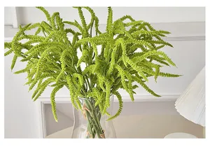 Detail of green artificial hanging amaranth plant in a transparent glass vase