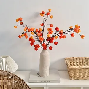Rami di bacche arancioni artificiali in vaso di ceramica per decorazione domestica moderna