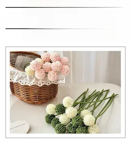 Close-up of colorful round artificial flowers in a brown woven basket with white lace