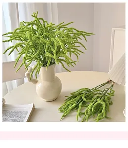 Close-up of artificial green weeping plant in a modern ceramic vase for home decor
