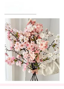 Macro shot of handheld long stem artificial cherry blossom bouquet in pink and white