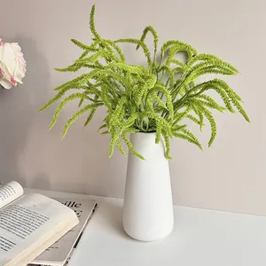 Artificial hanging greenery plant in a white ceramic vase for home and hotel interior decor