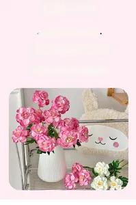 Detail of life-like faux peony petals and green leaves in a home decor setting