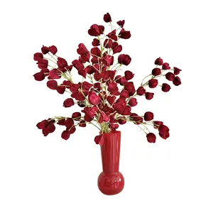 Deep burgundy lantern fruit silk flower arrangement in a matching red ceramic vase