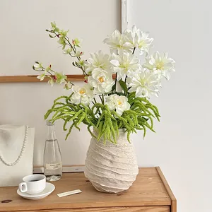 Artificial white dahlia floral arrangement in a beige spiral textured ceramic vase