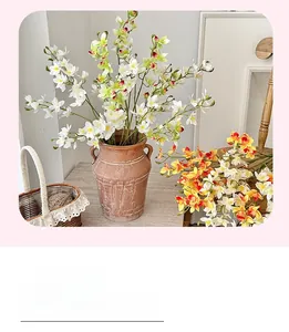 Detail view of multi-color artificial vanda orchids in a vintage brown ceramic vase