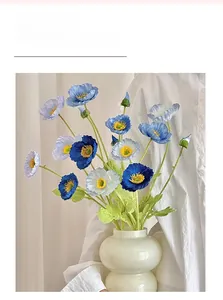 Detailed view of blue and white silk poppy flowers in a minimalist ceramic vase