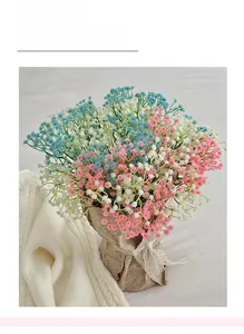 Detail of colorful artificial gypsophila bouquets in kraft paper with lace bow