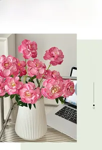Close-up of pink artificial peonies in a white ribbed vase for home floral decoration