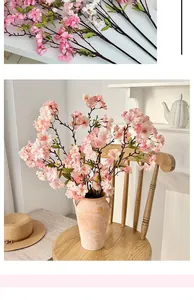 Close-up of artificial cherry blossom branches with dense pink and white petals in a vase