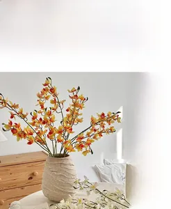 Artificial orange vanda orchids in a beige textured ceramic vase for home decoration