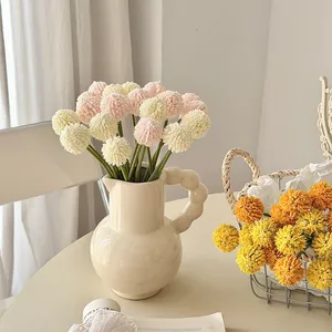 Artificial craspedia globosa pompom dandelion flowers in a modern ceramic vase