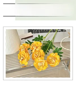 Close-up of realistic yellow buttercup silk flowers with layered petals in a vase