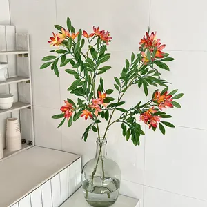 Lifelike orange trumpet artificial flowers with green foliage in glass vase for home decor