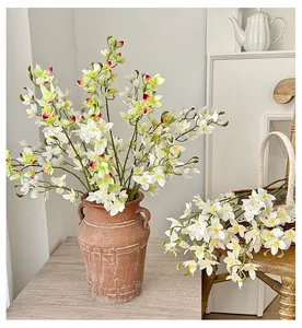 Artificial orchid in vintage clay vase with realistic white and green petals for home decor