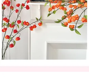 Détail de branches de physalis artificielles orange avec des feuilles vertes réalistes