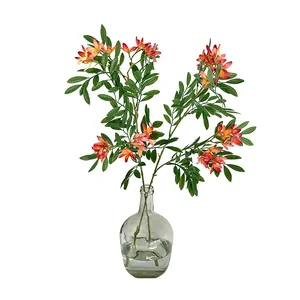 Artificial silk flower branch with pink to orange gradient petals in a glass vase