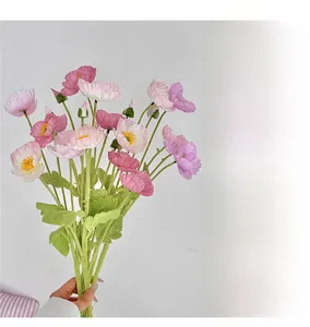 Close-up of artificial poppy bouquet with pink petals and green flocked stems