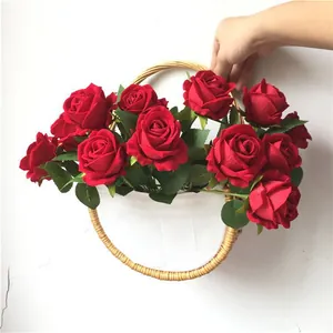 Detail van rode fluwelen kunstbloemen in een geweven rotan hangmand voor wanddecoratie