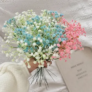 Artificial white blue and pink gypsophila bouquet in hand for home wedding decoration
