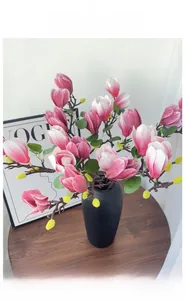 Détail de pétales de magnolia réalistes dans un vase en céramique noir mat élégant